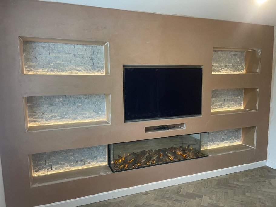 Wall with built-in shelves, a TV, and a glass-fronted fireplace beneath.