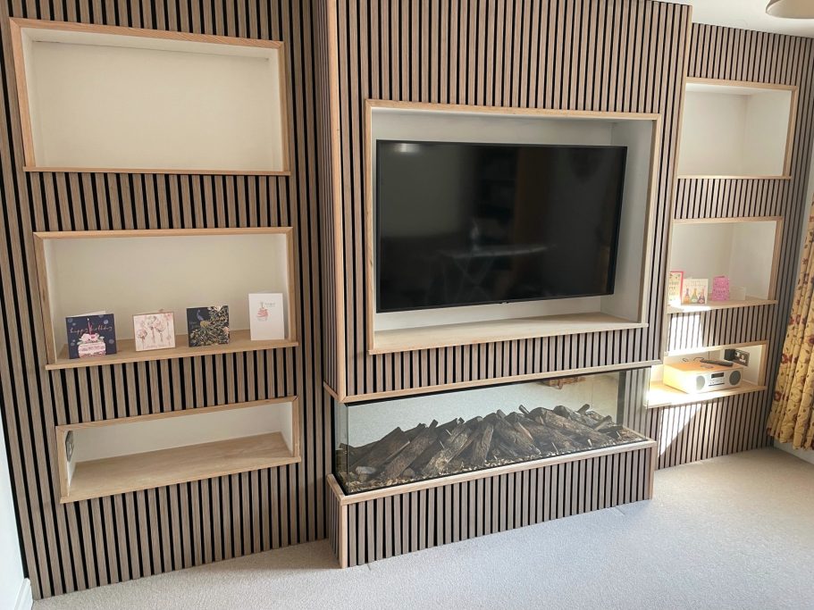 Modern living room with an acoustic slat feature wall, TV and modern electric fire