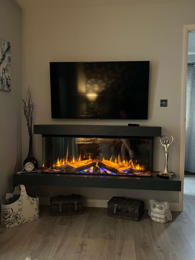 Modern living room with a wall-mounted TV above a sleek electric fireplace.