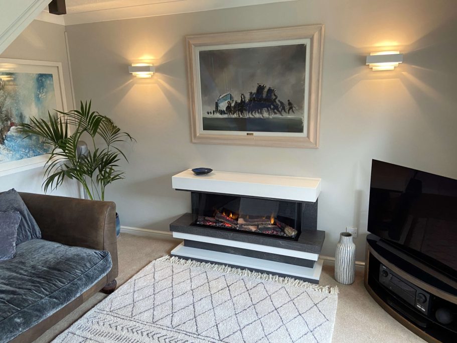 Modern living room featuring a fireplace, artwork, sofa, and stylish decor.